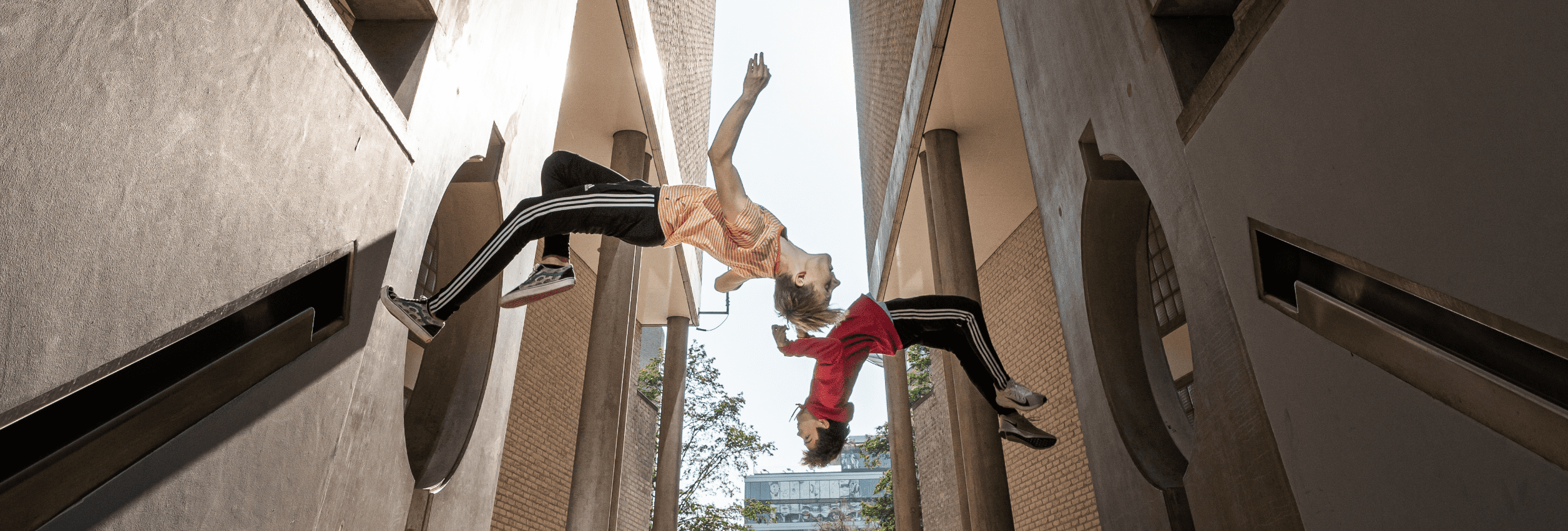 twee wallflips tegen de muur door professionele freerunners